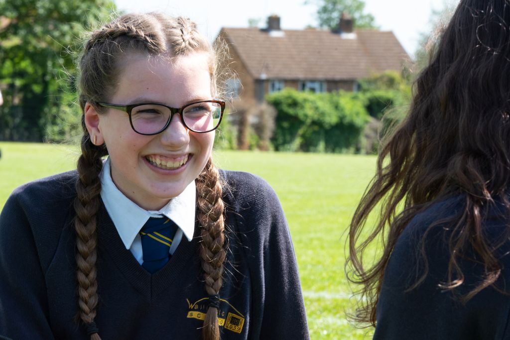 Girl smiling on school field.